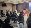 화면의 스크린에는 여수시도시관리공단 직무스트레스, 클래식으로 휴식하다 일시 2024년 12월 11일 (수) 15:00 ~ 16:00 쵸빙 룩스앙상블 바이올린 이은주 첼로 김채연 피아노 김수현 소프라노 안온유 라는 문구가 적혀있는 화면이 띄워져 있으며 50대 여성으로 보이는 여성이 마이크와 행사지를 들고 행사를 진행하고 있고, 임직원들은 경청하는 모습이다.