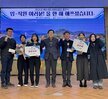 '2024년 여수시도시관리공단 종무식 임·직원 여러분! 올 한 해 애쓰셨습니다. 여수시도시관리공단 일자 : 2024.21.31 (화)'라는 문구가 적힌 대형 화면을 배경으로 같은 문구가 적혀진 현수막을 들고 여수시도시관리공단 임직원들이 단체로 촬영한 기념사진이다. 사진에는 30여 명의 임직원이 참여했으며 연령대는 20대에서 60대까지 다양하다. 2명의 남자 직원의 현수막을 길에 펼치며 앉아 있고, 가운데에는 50대 남성과 여성이 나란히 서 있으며, 전체적으로 단정한 복장으로 정돈된 분위기 속에서 한 해의 마무리를 기념하고 있다.