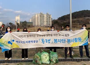 시민과 함께하는 상생경영 실현을 위한 노사활동 여수시도시관리공단 동행 봉사단 봉사활동 현수막을 든 봉사단의 기념촬영 모습