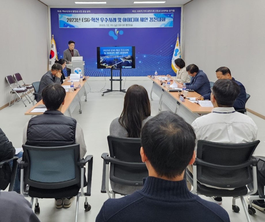 한명의 남성이 2023년 ESC 혁신 우수사례 및 아이디어 발표를 하고 6명의 심사위원과 다수의 사람들이 발표를 듣고 있는 모습