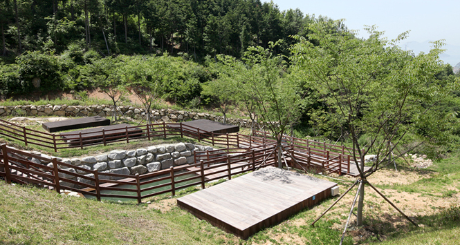 나무와 울타리가 있는 봉황산 자연휴양림 야영장의 모습