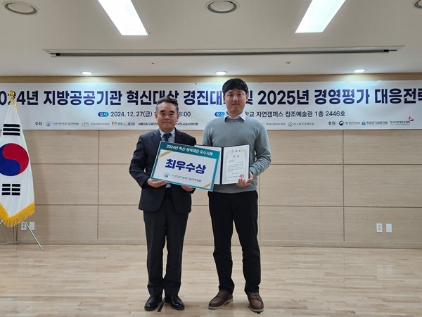 2024년 지방공공기관 혁신대상 경진대회 및 2025년 경영평가 대응전략 현수막이 걸려있고, 최우수상 팜플랫 카드와 상장을 들고 있는 수상자들의 모습