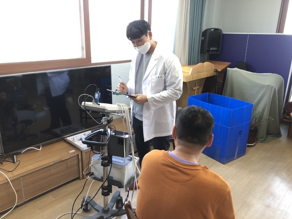 건강운동관리사가 어르신의 체성분분석을 하는 모습