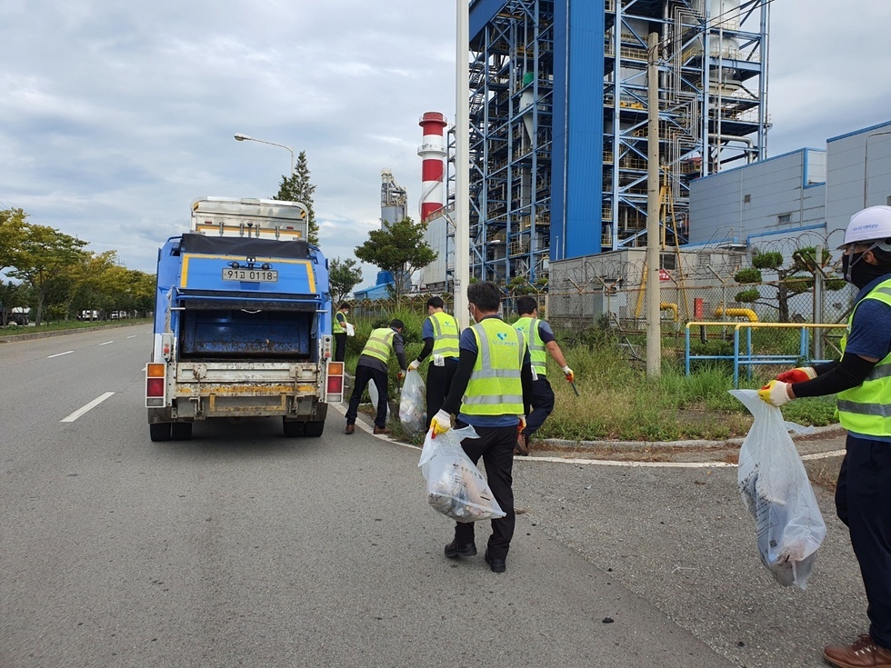 산단 내 도로의 적체된 폐기물을 운반차와 환경미화원들이 청소를 하는 모습