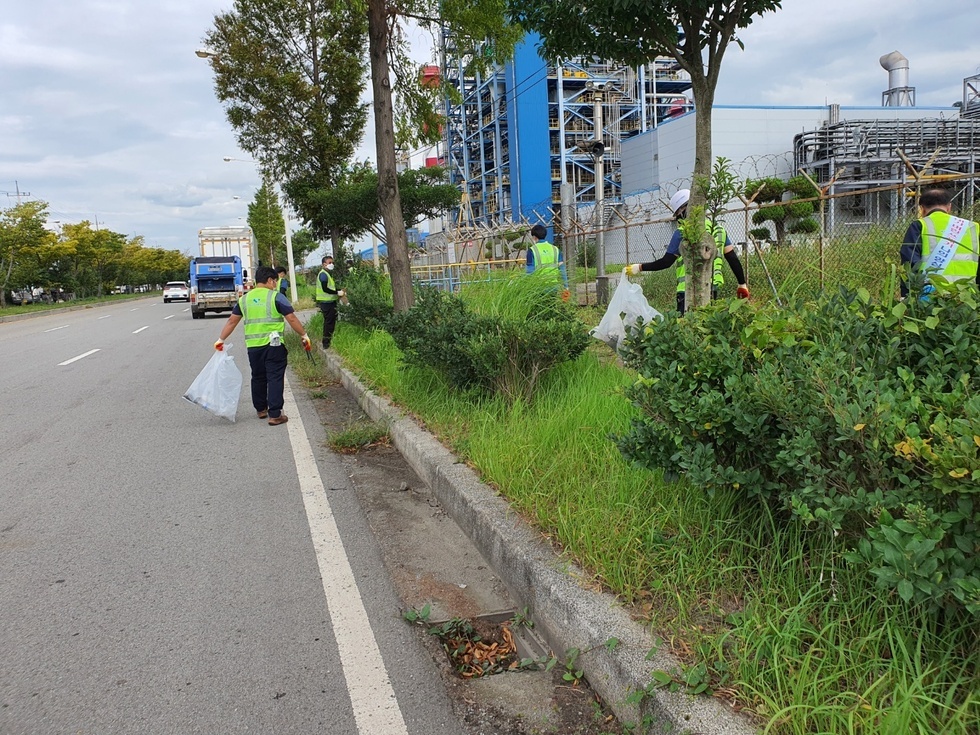 도로 옆 화단에 쓰레기를 청소하는 환경미화원들의 모습