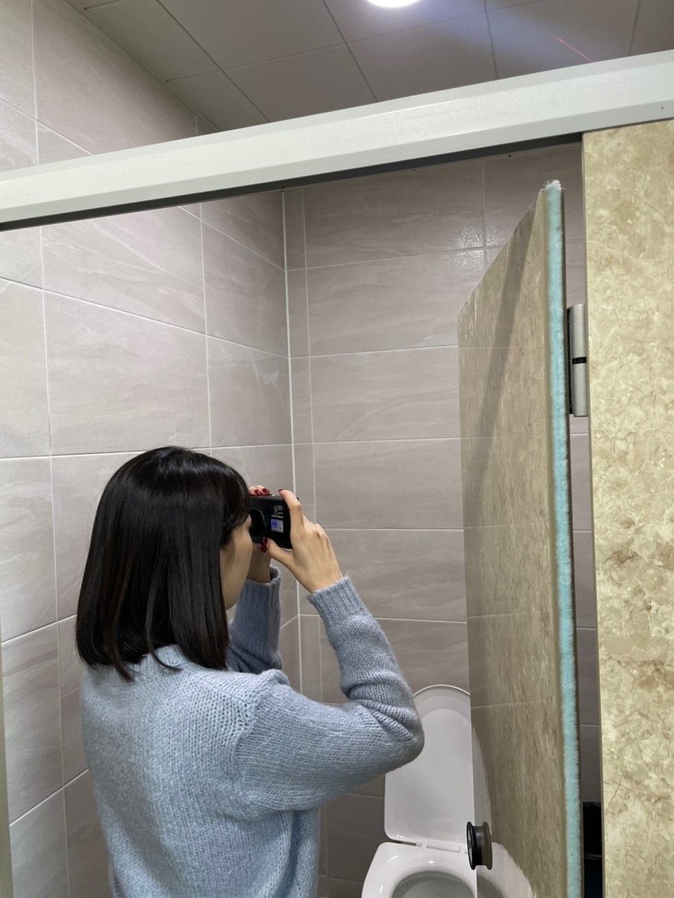 공용화장실을 점검하는 여성 직원의 모습