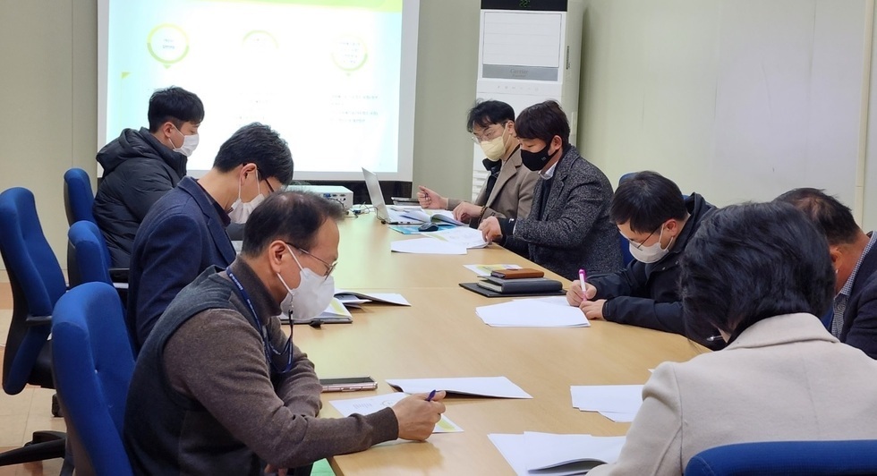 김유화 이사장과 관계자들이 테이블에 둘러 앉아 회의를 하고 있는 모습