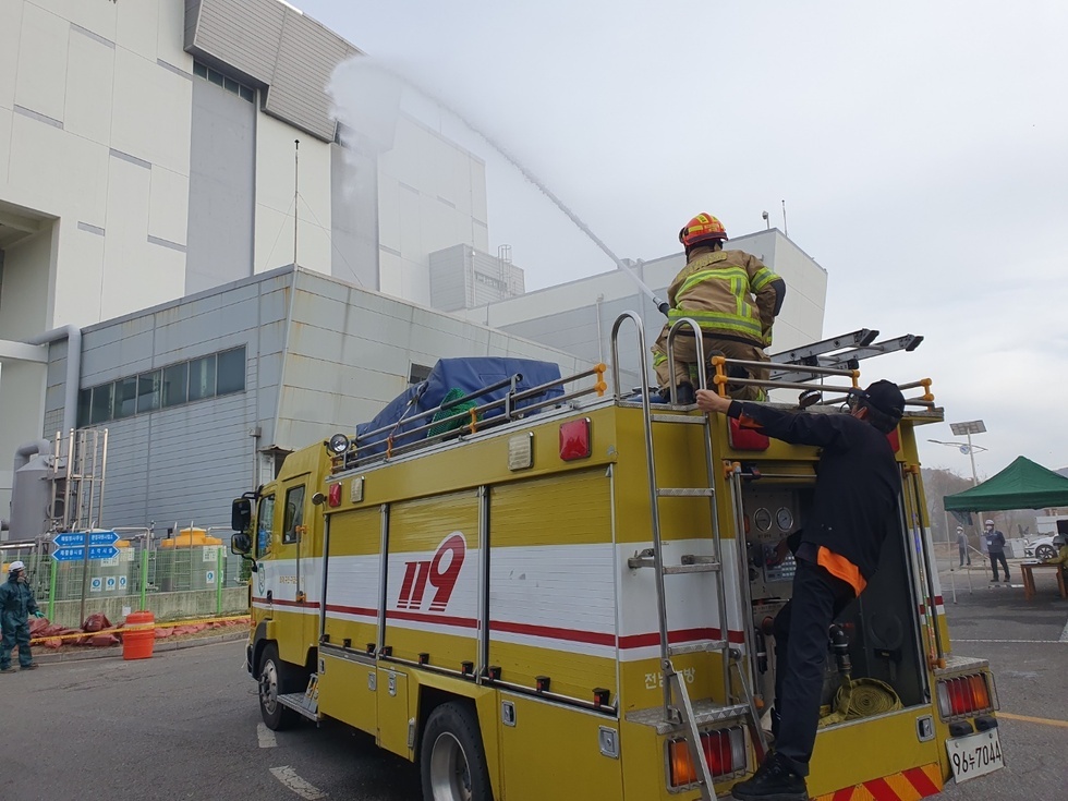 재난대응 안전한국훈련에 참여한 소방공무원들이 119차량에 올라타 소방호스를 들고 화재진압 훈련을 하는 모습