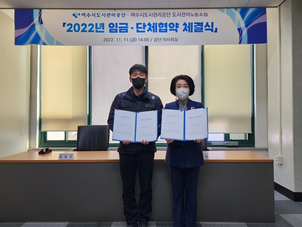 2022년 임금·단체협약체결식에 참석한 김유화이사장과 도시관리노동조합 주용우위원장이 협약서를 들고 기념촬영을 하고있는 모습