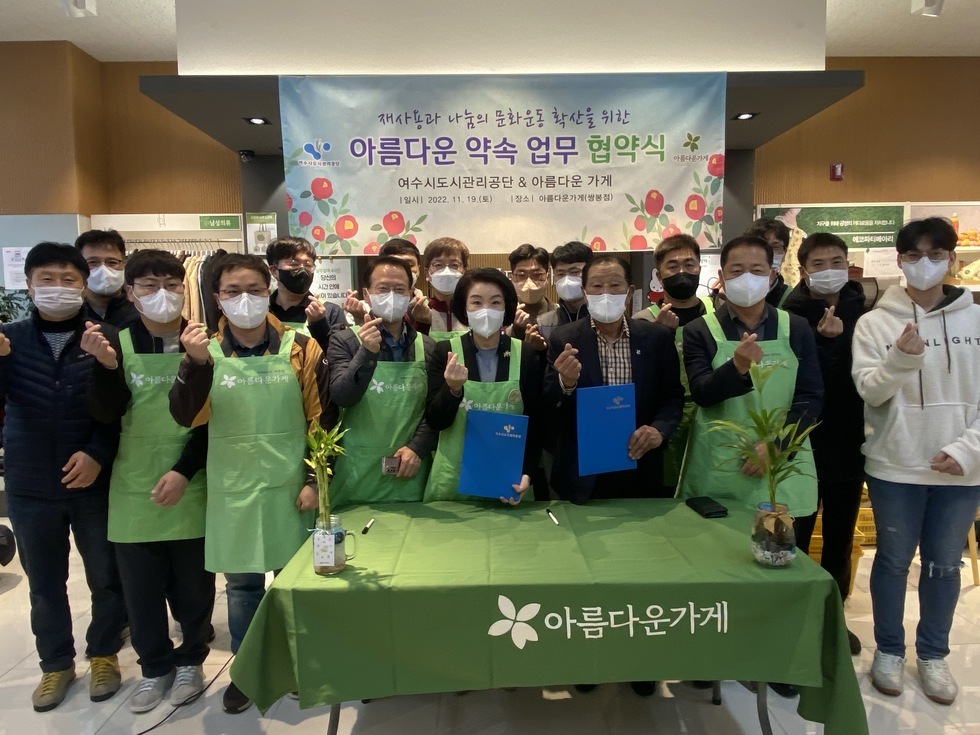 재사용과 나눔 문화 확산 업무협약식에 참석한 김유화 이사장과 관련자들이 손하트 포즈를 하고 단체 기념촬영을 하는 모습