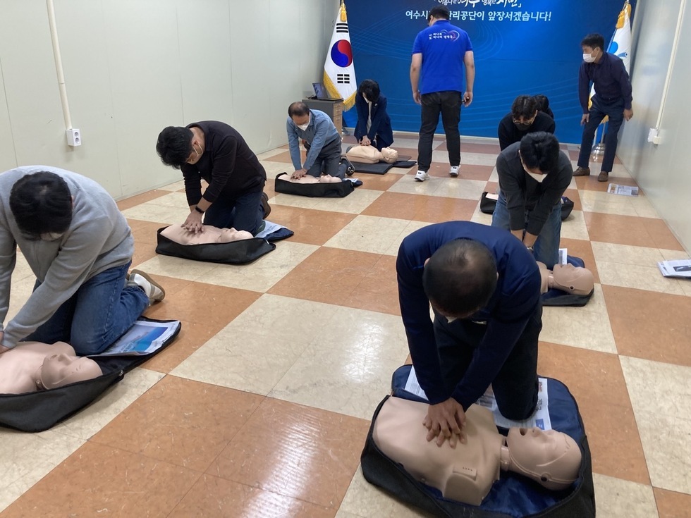 전직원 심폐소생술 교육에 참석한 직원들이 마네킹의 가슴에 손을 겹쳐 대고 심페소생술 교육을 받고있는 모습