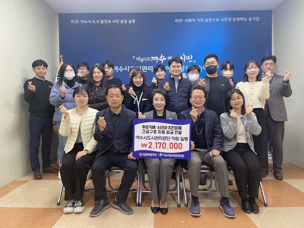  [튀르키예시리아 지진피해 긴급구호 지원 성금전달 여수시도시관리공단 직원일동이 217만원]이 적힌 팻말을 들고 있는 김유화 이사장과 임직원들의 성금기부 단체기념 촬영 모습