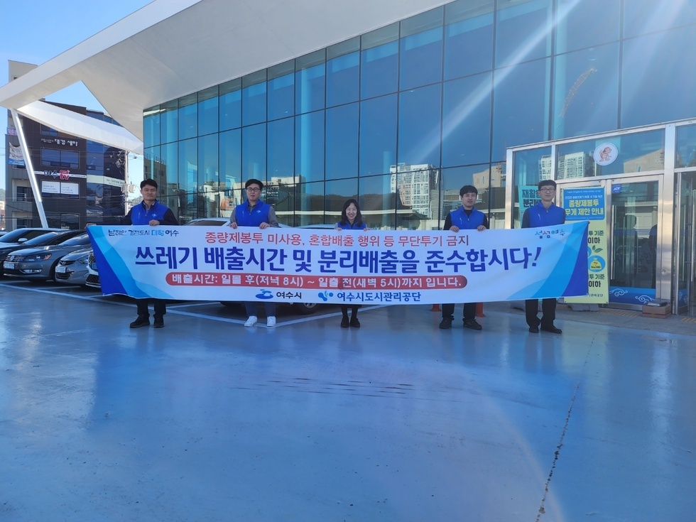 종량제봉투 미사용, 혼합배출 행위 등 무단 투기 금지 / 쓰레기 배출 시간 및 분리 배출을 준수 합시다/ 배출 시간 : 일몰 후(저녁 8시) ~ 일출 전 (새벽 5시)까지 입니다 / 여수시, 여수도시관리공단 이라고 적힌 큰 현수막을 파란색 옷을 입은 사람들이 들고 있는 사진