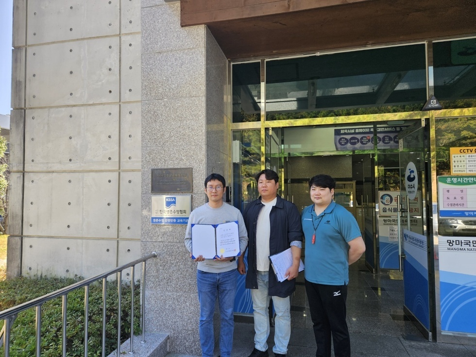 세명의 남성들이 한국생존수영협회 간판이 붙은 건물 앞에서 상장을 들고 사진을 찍고 있는 모습