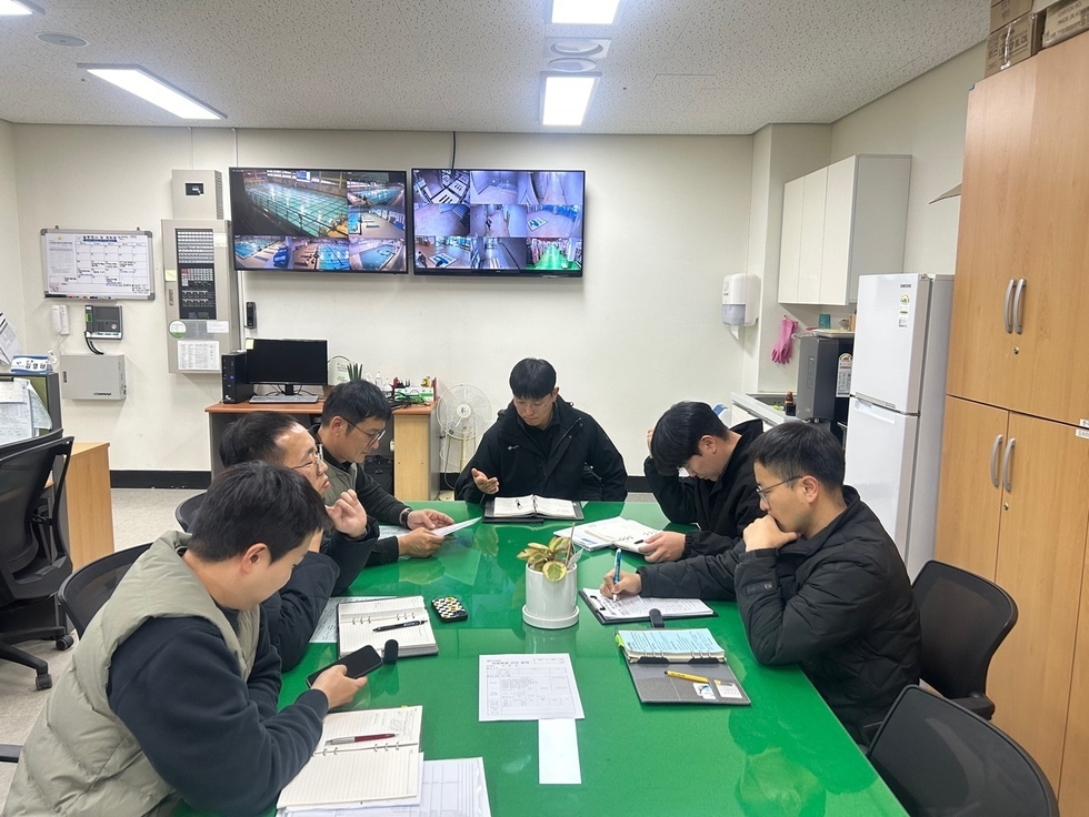 공단 관계자들이 초록색 테이블에 둘러 앉아 회의를 하고 있는 모습