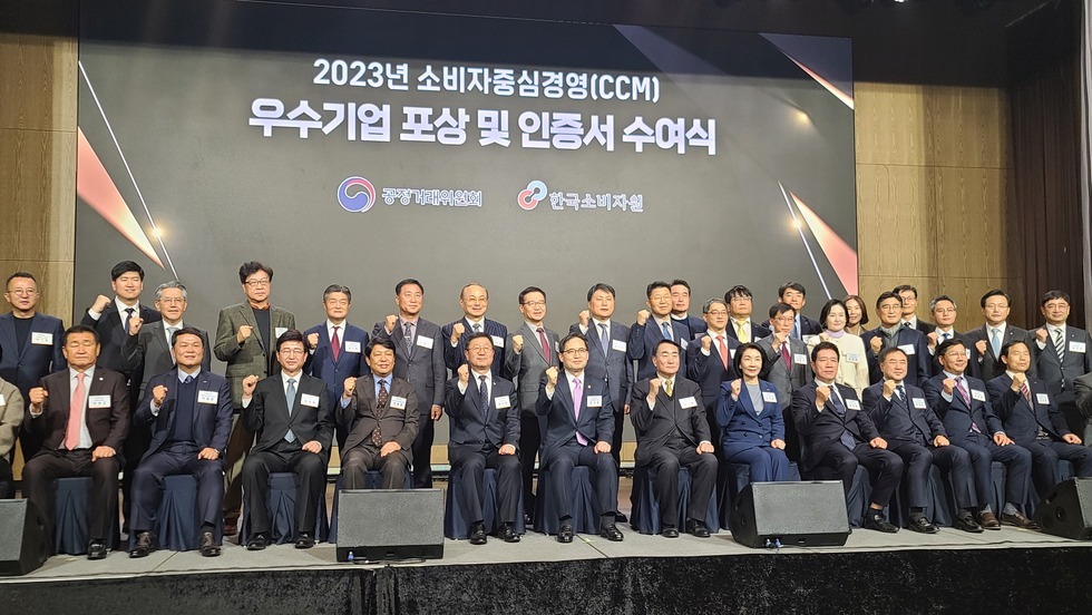 2023년 소비자 중심경영(CCM) 인증서 수여식 배경 앞에 관계자들이 앉아서 사진을 찍고 있는 모습