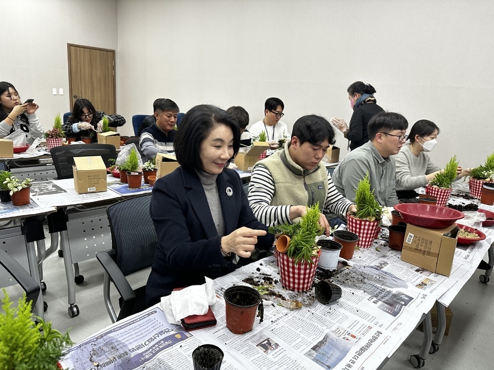 공단 관계자들이 신문지가 깔린 책상 위에서 꽃꽂이를 하고 있는 모습