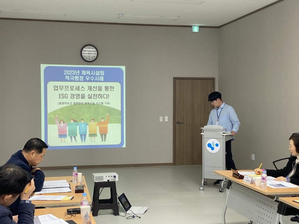 2023년 체육시설팀 적극행정 우수사례 ESC 경영을 실천하다!(쳬계적으로 일원화된 체육 시설 시스템 구축) 에 대하여 남성이 발표하고 3명의 사람들이 앉아서 경청하고 있는 모습