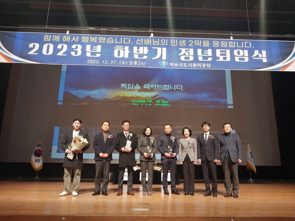 함께해서 행복했습니다 / 선배님의 인생 2막을 응원합니다 / 2023년 하반기 정년 퇴임식 / 2023.12.27(수) 오후 2시 여수도시관리공단 현수막 아래에 8명의 사람들이 서 있는 모습