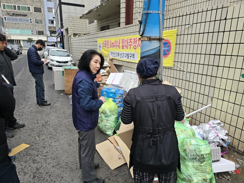 4명의 사람들이 폐기물 앞에서 이야기를 나누고 있는 모습