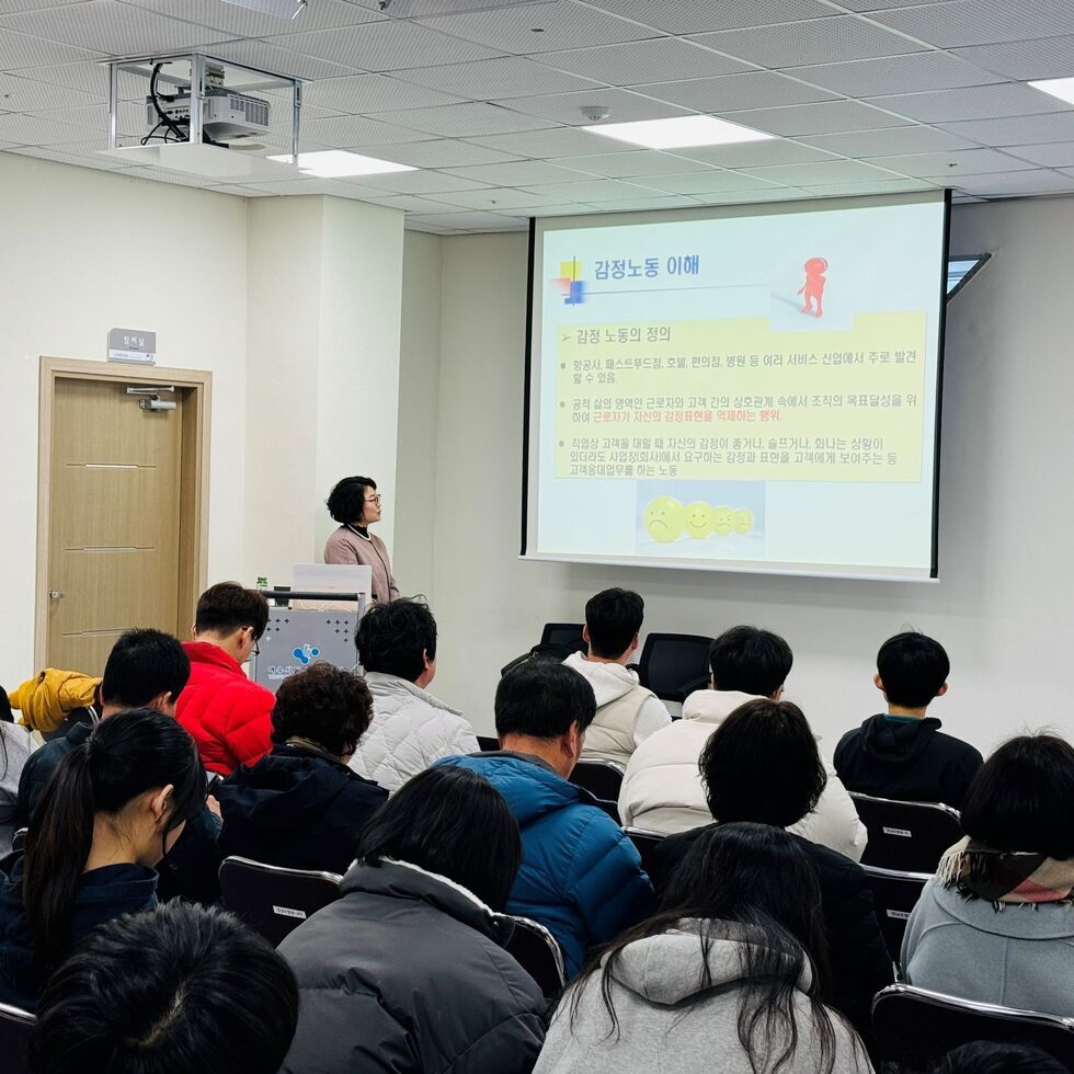 공단 이사장이 교단 앞에서 스크린을 보며 직원들에게 교육 하고 있는 모습