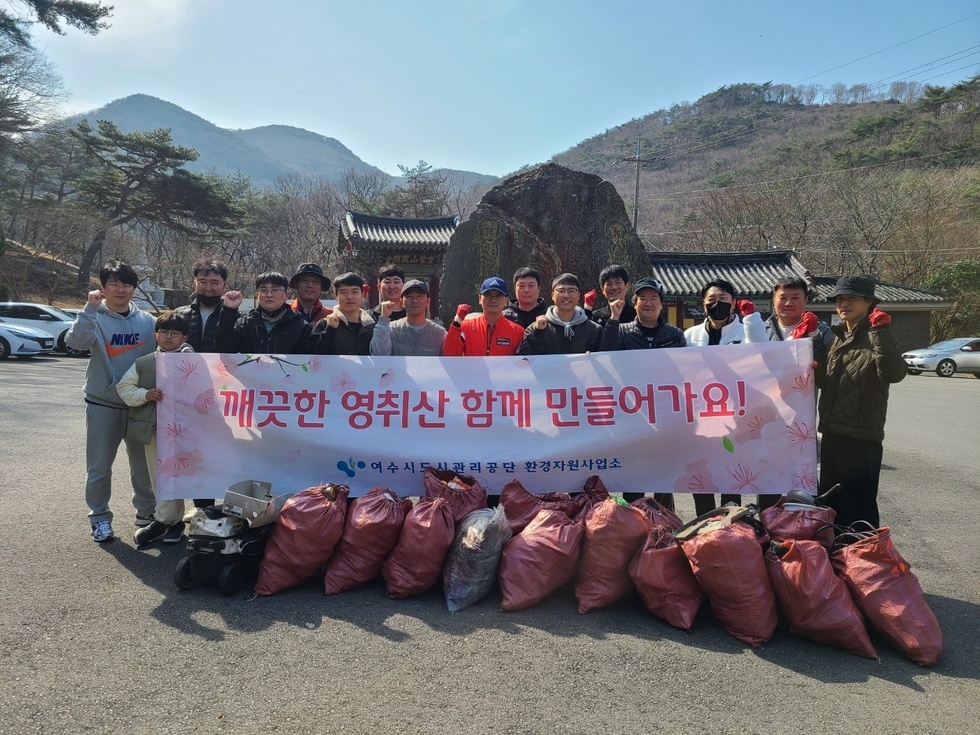 환경자원사업소 20여명의 직원들이 환경정화활동 후 현수막(깨끗한 영취산 함께만들어 가요! 여수시도시관리공단 환경자원사업소)을 들고 단체 기념촬영을 하는 모습