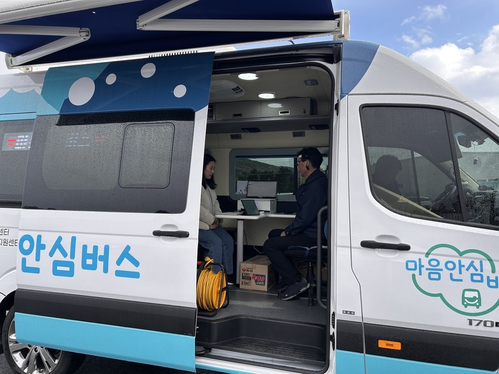 '안심버스 마음안심' 문구가 적힌 버스안에서 중년남성과 젊은여성이 마주보고 앉아 상담을 하고 있는 모습