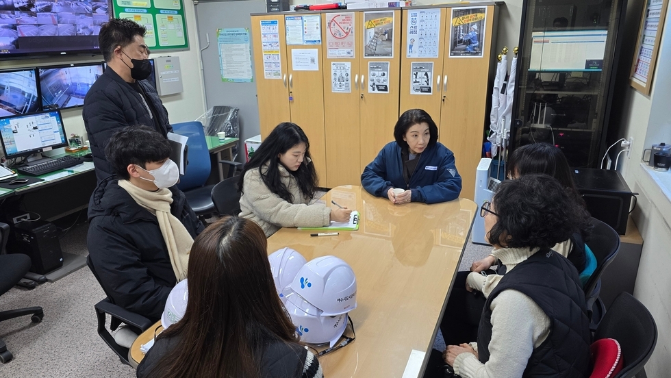 여수도시관리공단 김유화 이사장님과 6명의 직원들이 테이블에 앉아서 토론을 하고 있는 모습이다. 뒤로는 여러대의 컴퓨터와 현장모니터 그리고 옷장들이 있다.