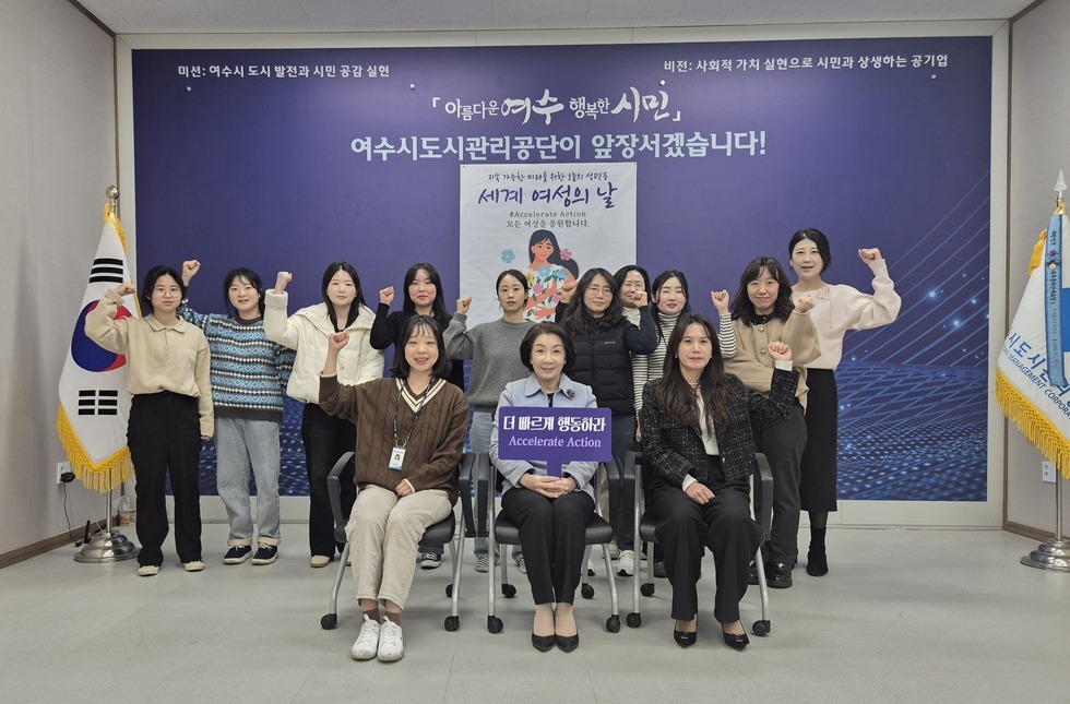 '더 빠르게 행동하라 Accelate Action' 이라고 적힌 팜플렛을 들고있는 여수시도시관리공단 김유화 이사장님과 여수시도시관리공단 여성직원분들이
'미션: 여수시 도시 발전과 시민 공감 실현
비전: 사회적 가치 실현으로 시민과 상생하는 공기업
아름다운여수 행복한시민
여수시도시관리공단이 앞장서겠습니다!
지속 가능한 미래를 위한 오늘의 성평등
세계 여성의 날
#Accelerate Action
모든 여성을 응원합니다.'
라고 적힌 현수막이 붙어있는 벽 앞에서 한 손을 들고 화이팅을 하는 모습을 찍은 사진이다.